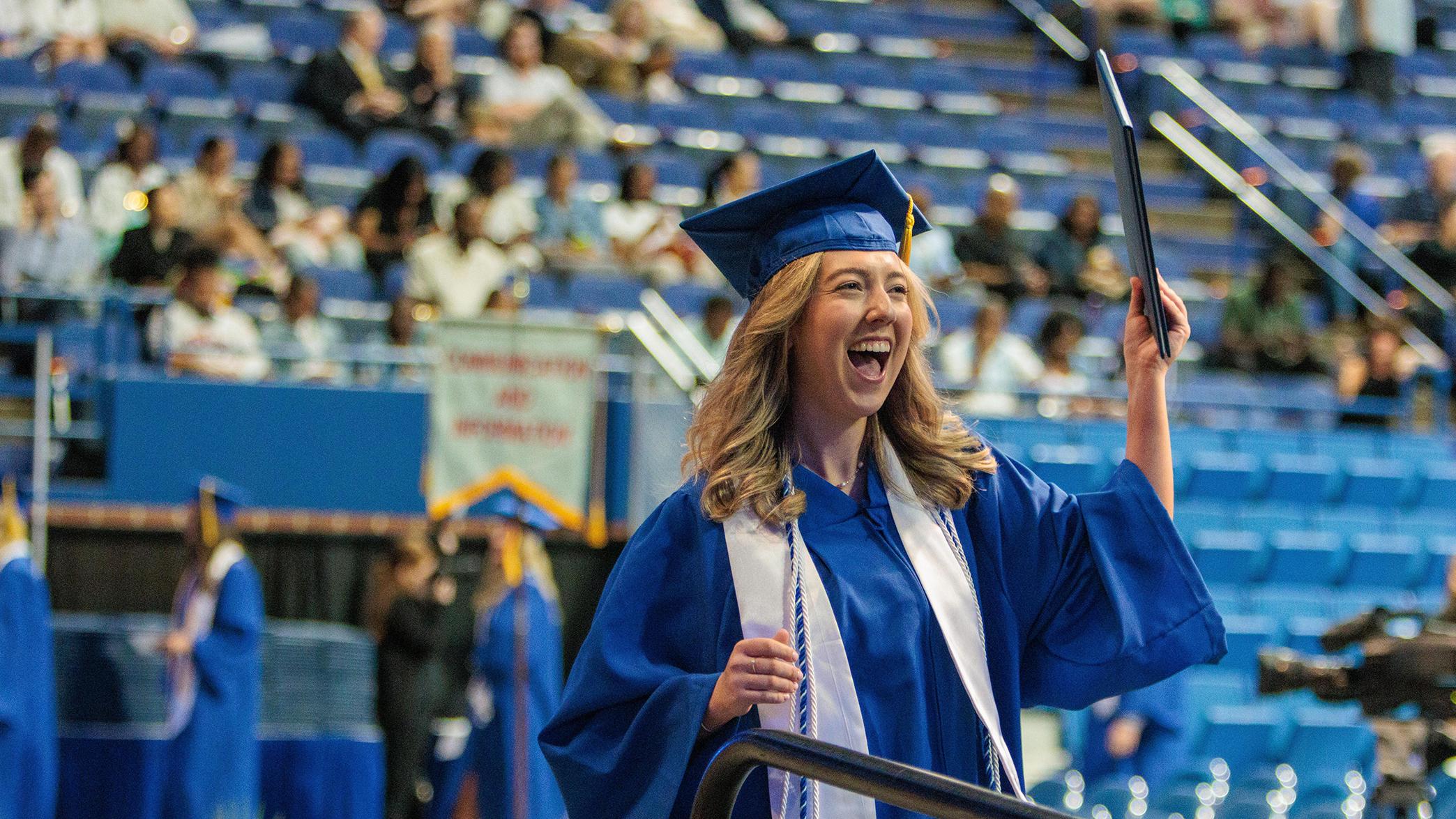 A graduate celebrates with their diploma