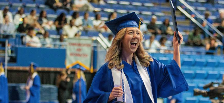 A graduate celebrates with their diploma